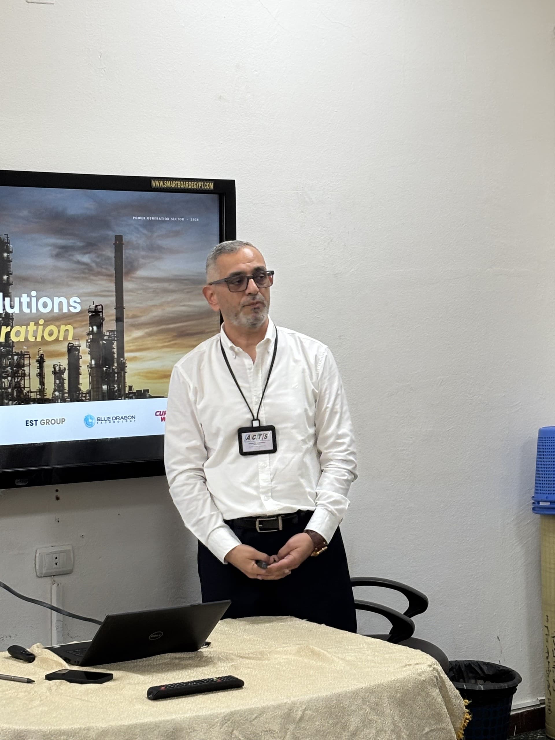 An ACTS speaker presenting the company, beside a screen showing its partner brands
