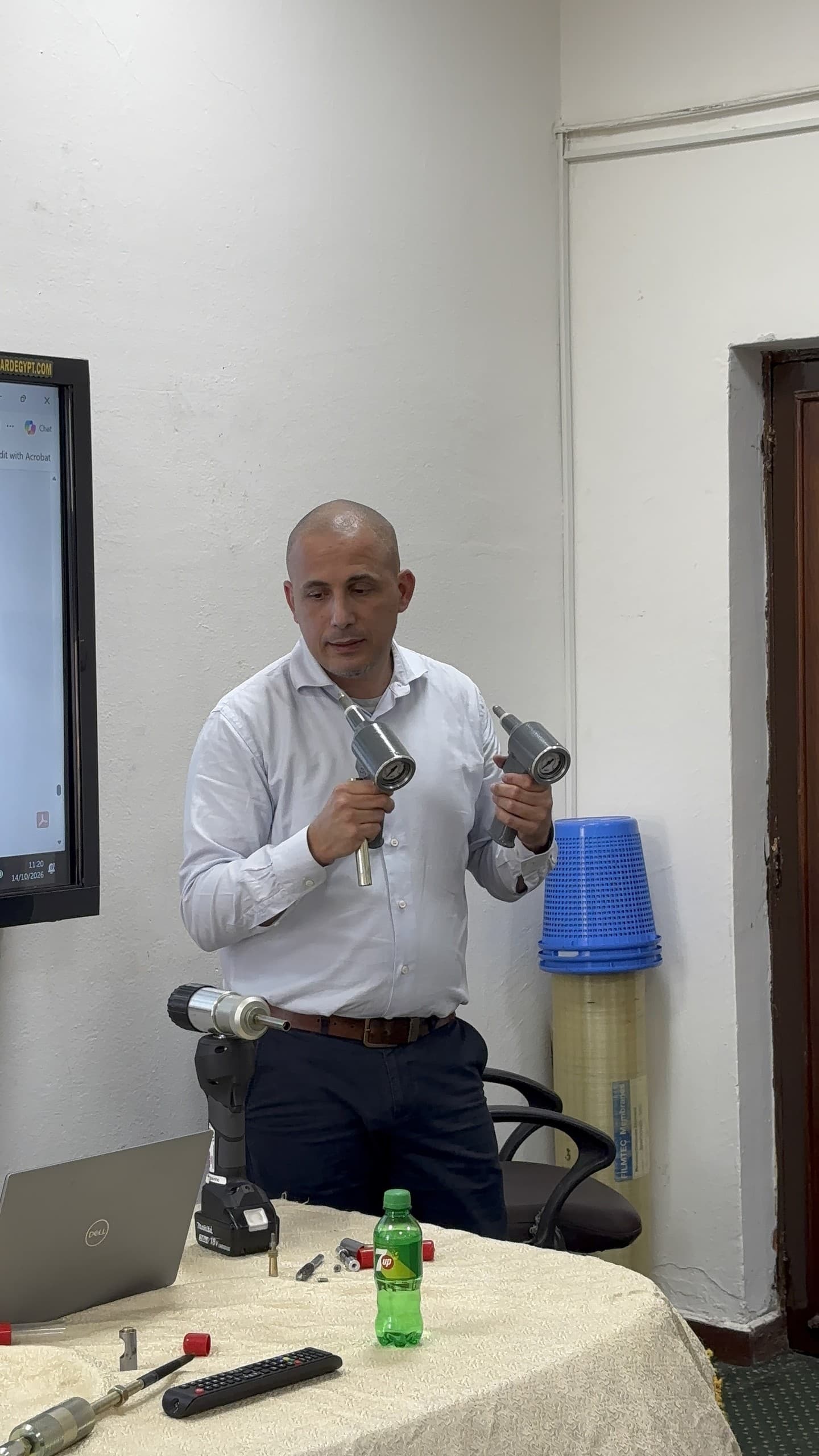 An EST Group engineer holding two installation tools during the live demonstration