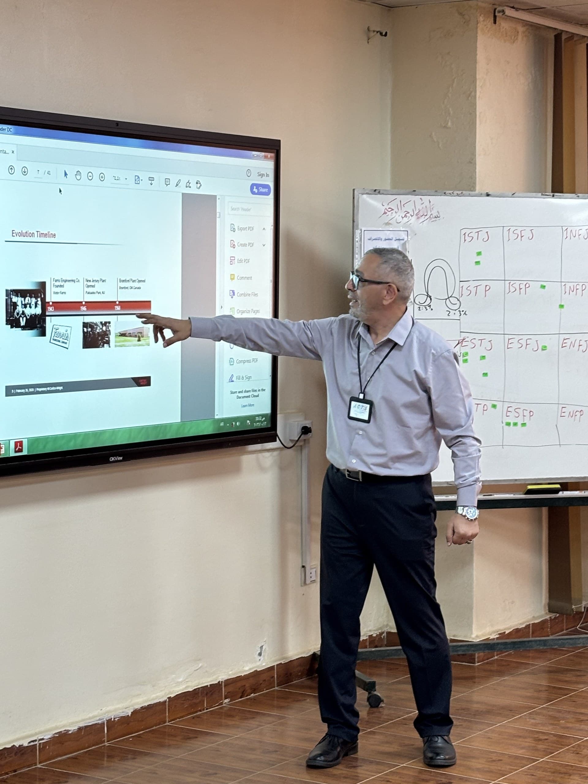An EST Group presenter pointing to a product slide beside a whiteboard of notes