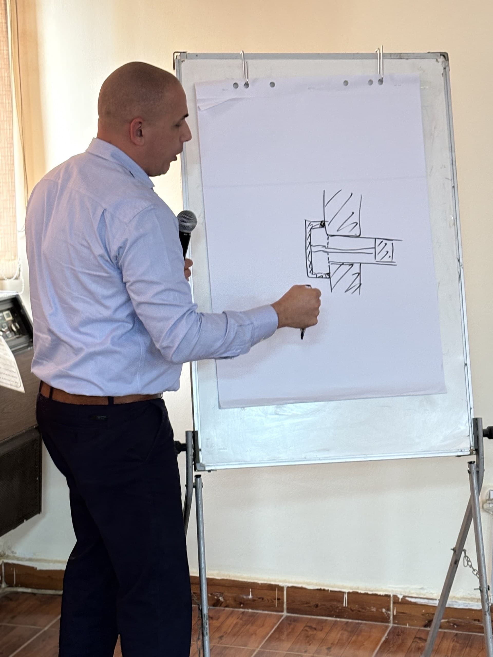 An EST Group engineer sketching a plug seated in a heat exchanger tube on the flipchart